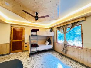 a bedroom with a bunk bed and a window at Man Mauji Villa in Kasol