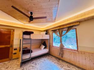 a room with a bunk bed and a window at Man Mauji Villa in Kasol
