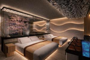 a bedroom with two beds and a television in it at Hotel MAISAKURA MIYABI in Nara