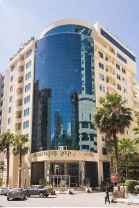 a large building with cars parked in front of it at Elilly International Hotel in Addis Ababa
