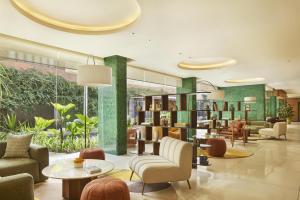 a lobby with chairs and tables and bookshelves at Kleo Seminyak, part of JdV by Hyatt in Seminyak