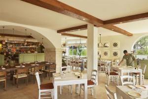 a man standing in a restaurant with tables and chairs at Kleo Seminyak, part of JdV by Hyatt in Seminyak +77 photos