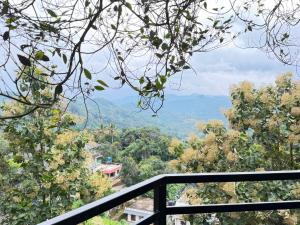 a view of the mountains from a balcony at Happy Days by 3R Munnar in Munnar