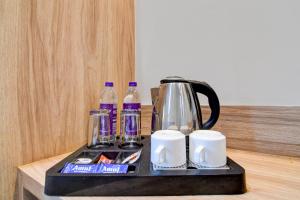 a black tray with a coffee maker and bottles of water at Palette Dumdum Airport Formerly Seventy-Seven in Dum Dum