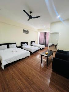 a hotel room with three beds and a couch at Black Forest Hotel in Kalām