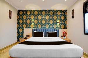 a bedroom with a large bed and a blue curtain at Palette Dumdum Airport Formerly Seventy-Seven in Dum Dum