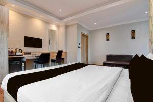 a bedroom with a bed and a desk with a computer at Palette Dumdum Airport Formerly Seventy-Seven in Dum Dum