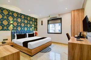 a hotel room with a bed and a television at Palette Dumdum Airport Formerly Seventy-Seven in Dum Dum