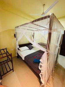 a bedroom with a bed with a canopy at Sun land Villa in Hikkaduwa