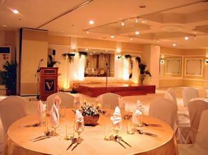 a room with a table with white chairs and a stage at Hotel Veniz in Baguio