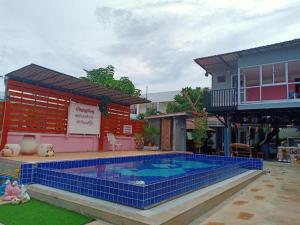 a large swimming pool in front of a house at Baan Gon Chompu in Suan Phung