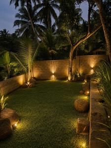 a garden lit up at night with lights at Atithya Retreat in Hikkaduwa
