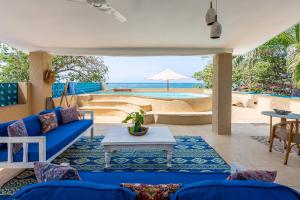 a living room with a blue couch and a table at Tequila Sunrise Sky Cabana-Diani Beach in Diani Beach