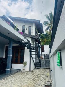 a white house with a spiral staircase on it at Jungle Breeze Villa in Melsiripura