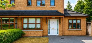 a brick house with a white door and windows at 28 Rathevan View Rosdarragh Portlaoise in Portlaoise