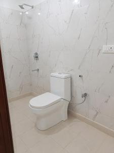 a bathroom with a white toilet and marble walls at Beach Resort in 1 in North goa