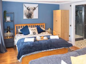 a bedroom with a large bed with blue walls at The Old Post Office in Kingskettle