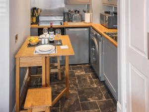 a small kitchen with a table and a dishwasher at The Old Post Office in Kingskettle