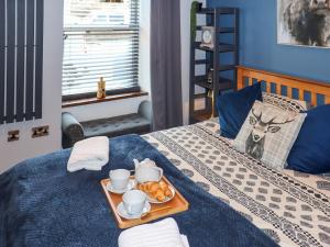 a tray with a tray of food on a bed at The Old Post Office in Kingskettle