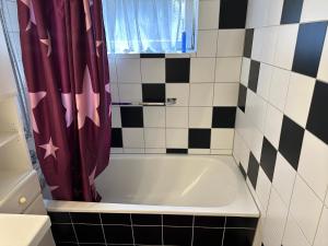 a bathroom with a tub and a shower curtain at Souterrain Zimmer mit Sauna in Klosterlechfeld