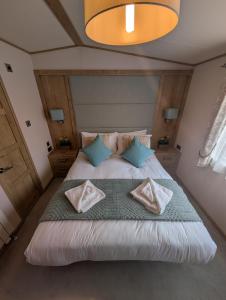 a bedroom with a large bed with pillows on it at New Forest holiday lodge in New Milton +50 photos