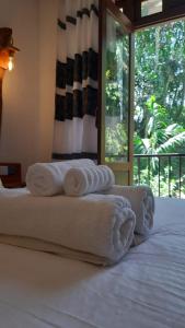 a group of towels sitting on top of a bed at Kadura Resort in Ella