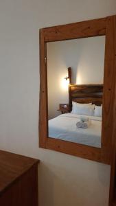 a mirror reflecting a bed in a bedroom at Kadura Resort in Ella