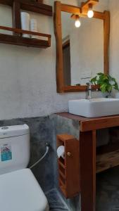 a bathroom with a sink and a toilet and a mirror at Kadura Resort in Ella