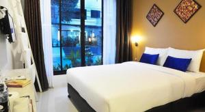 a bedroom with a large white bed and a window at U Sleep Chiangmai in Chiang Mai