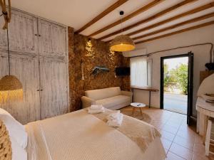 a bedroom with a bed and a couch at Atlazia Suites in Alinda