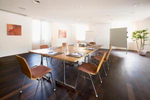 a conference room with a long table and chairs at Parkhotel Gunten – Beach & Spa in Gunten