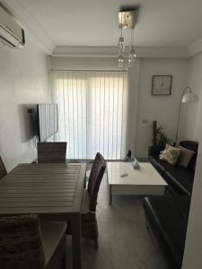 a living room with a table and a couch at Les pieds dans l eau, résidence Nadine in Hammam Sousse