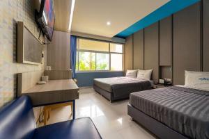 a hotel room with two beds and a television at Krungthai Hotel at Rangnam in Sathani Sam Sen