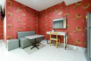 a room with a desk and a mirror on a red wall at Krungthai Hotel at Rangnam in Sathani Sam Sen