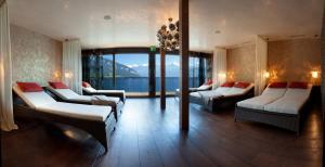 a room with two beds and a large window at Parkhotel Gunten – Beach & Spa in Gunten +73 photos