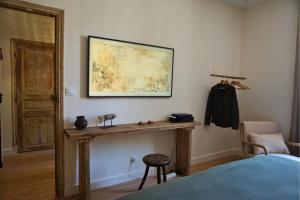 a bedroom with a table and a painting on the wall at Maison Constant - L'Erable in Autun