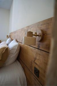 a wooden headboard of a bed with white pillows at Maison Constant - L'Erable in Autun