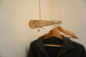 a wooden hanger with a black shirt hanging from it at Maison Constant - L'Erable in Autun
