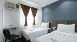 a hotel room with two beds and a window at Eighty Eight Hotel in Koronadal +182 photos