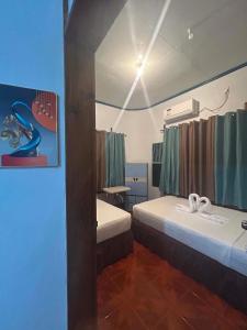 a hotel room with two beds and a mirror at Camiguin El Rio Dorado in Catarman