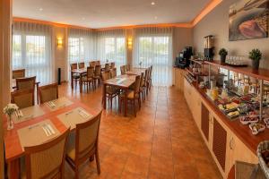 a restaurant with tables and chairs and a bar at Hotel am Hardtsee in Ubstadt-Weiher
