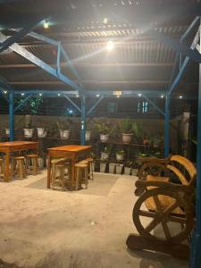 a group of tables and benches in a room with plants at Camiguin El Rio Dorado in Catarman