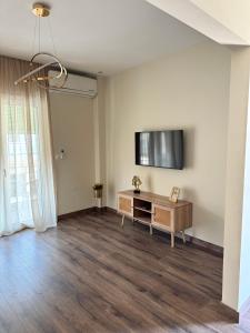 an empty living room with a flat screen tv on the wall at Nikoletta in Katerini