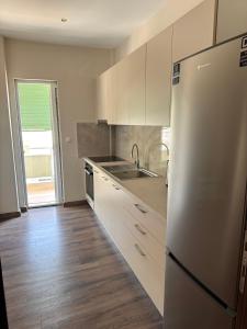 a kitchen with white cabinets and a stainless steel refrigerator at Nikoletta in Katerini