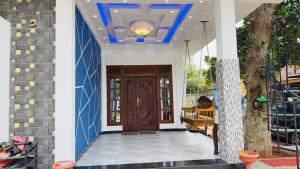 a front door of a house with a blue ceiling at A&T villa in Jaffna