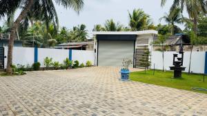 a house with a blue fire hydrant in the driveway at A&T villa in Jaffna