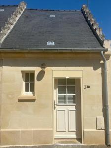 a small house with a door and a black roof at Une pause Altifontaine in Hautefontaine
