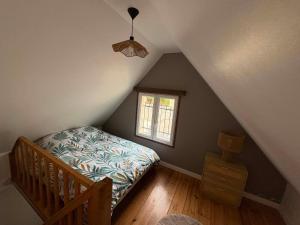 a attic bedroom with a bed and a window at Une pause Altifontaine in Hautefontaine