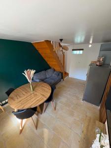 a living room with a table and a couch at Une pause Altifontaine in Hautefontaine