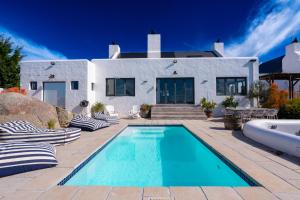 a swimming pool in front of a house at L'abri in Langebaan